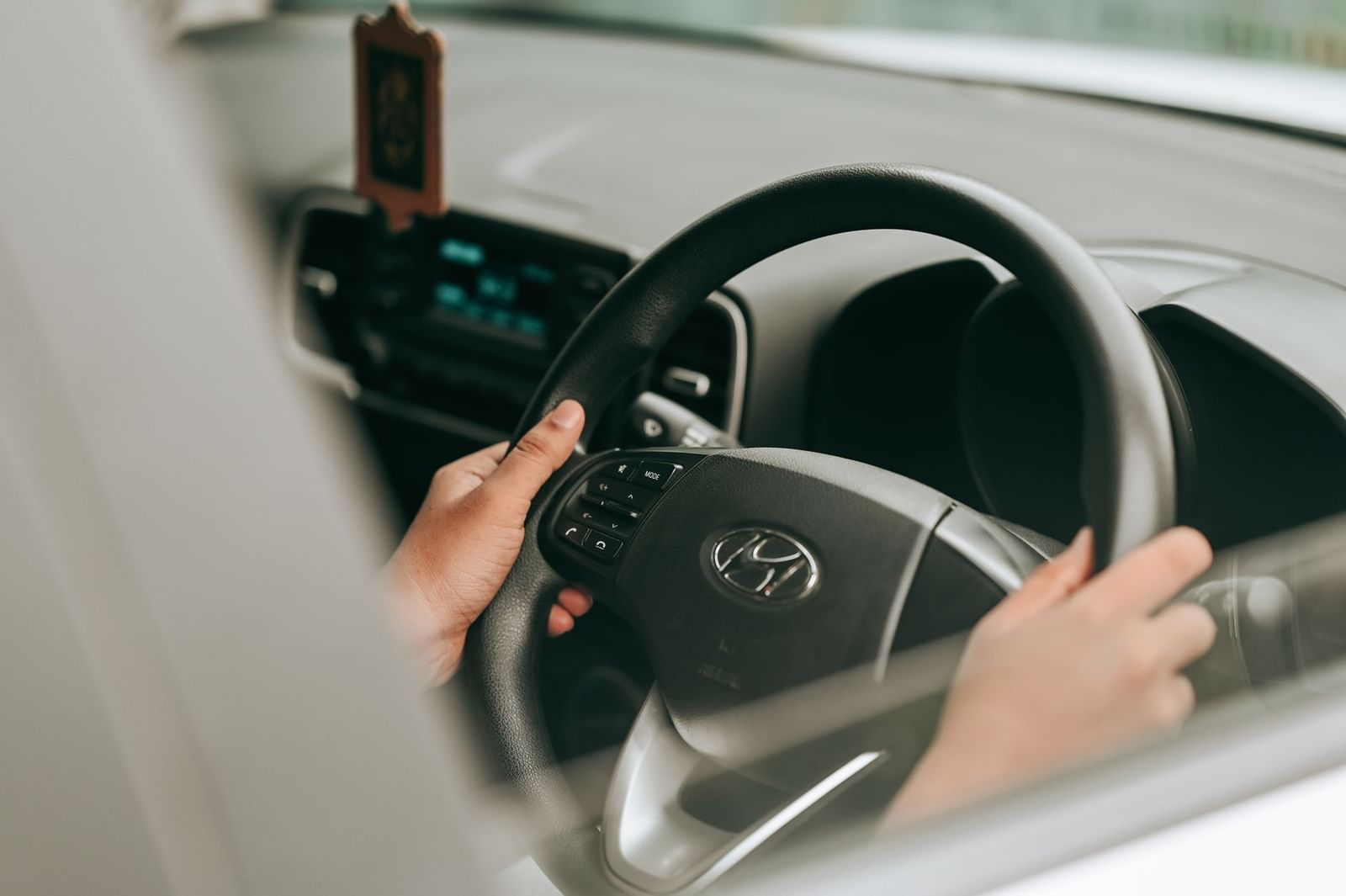 A learner driver's hands on the steering wheel during a lesson
