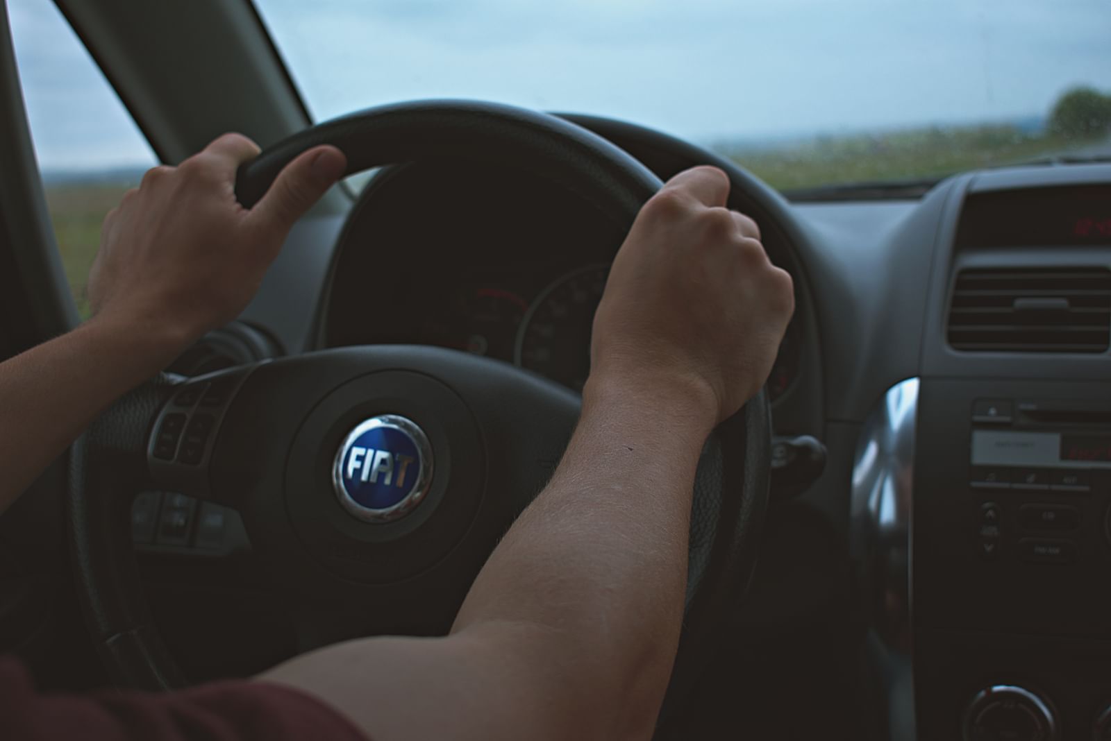 Close view of a learner's hands positioned correctly on a steering wheel