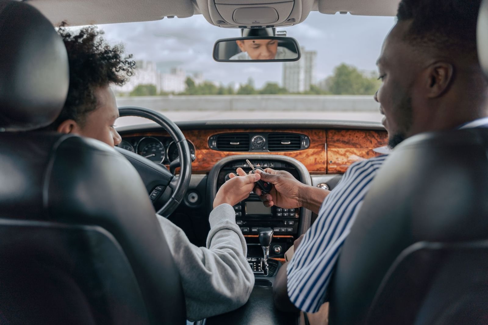 An instructor watching a learner driver from the passenger seat during a lesson