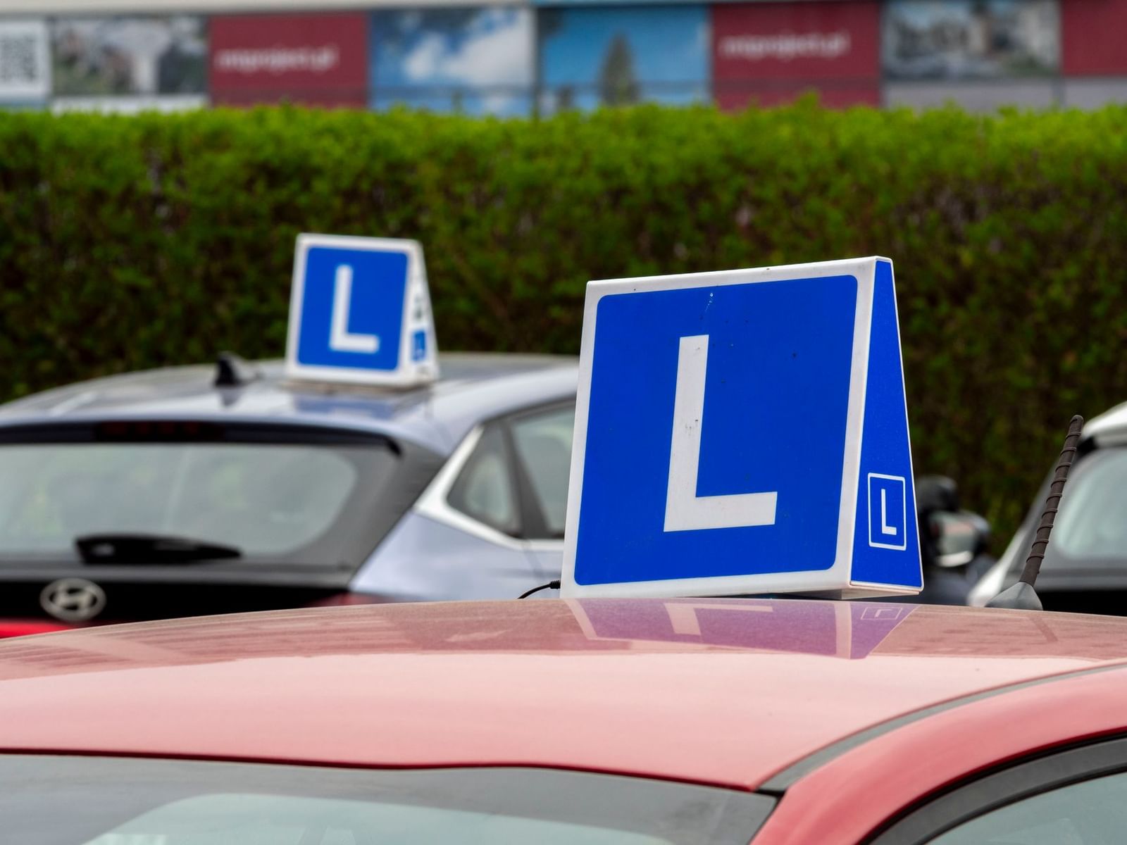A red L plate on the back of a learner car on a Dublin street